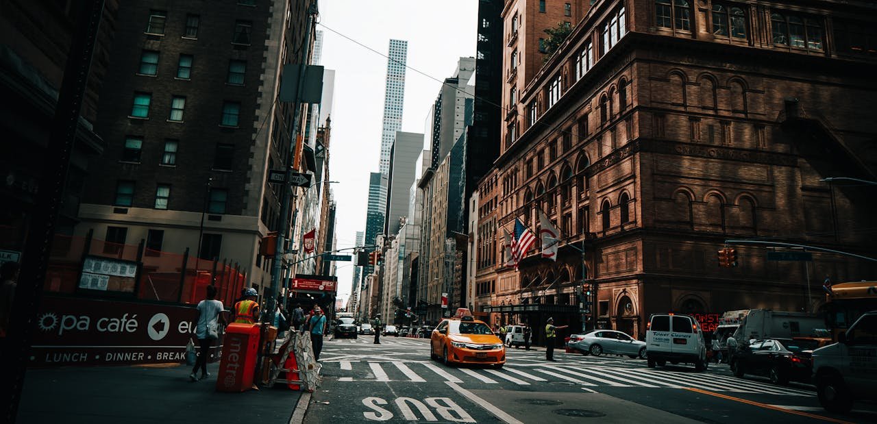 Vibrant New York City street with yellow taxi, skyscrapers, and city life captured in Midtown Manhattan.