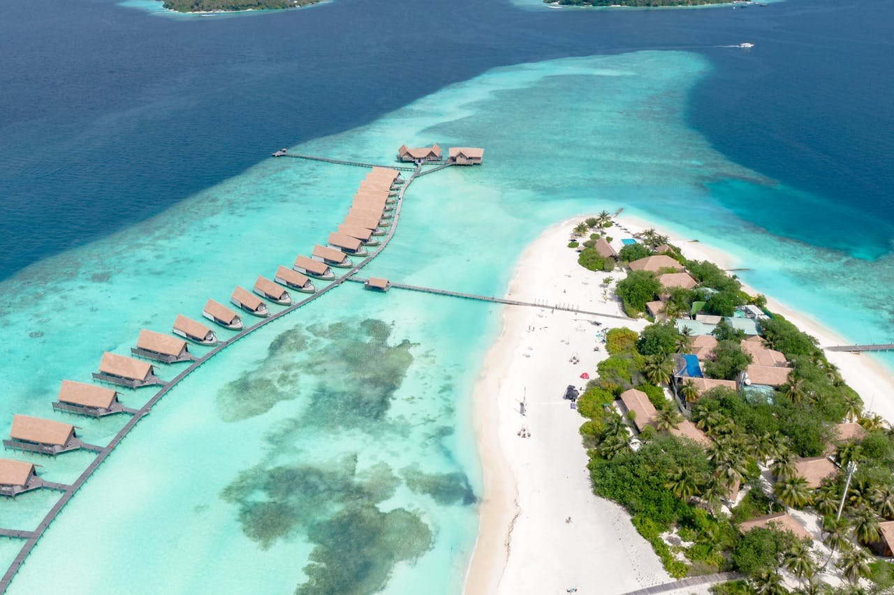 A breathtaking aerial view of overwater bungalows and pristine beaches in Kaafu Atoll, Maldives.